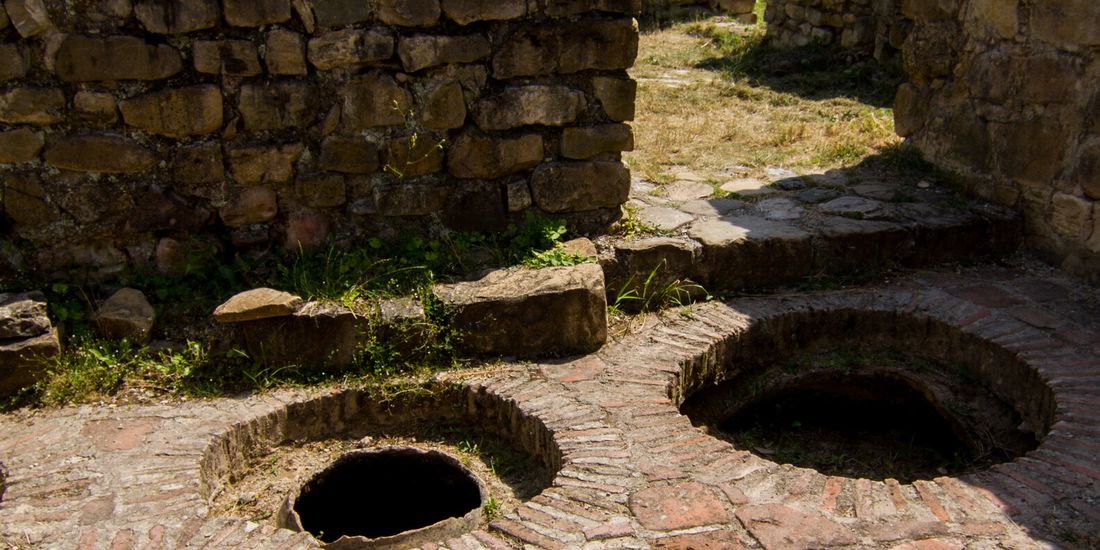 Mouths of buried qvevri among the ruins of Ikalto monastery in Kakheti, Georgia