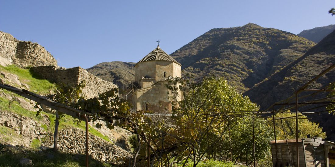 The 7th-century church of Ateni Sioni in the Tana gorge, with autumn vines on a village pergola in front, Kartli